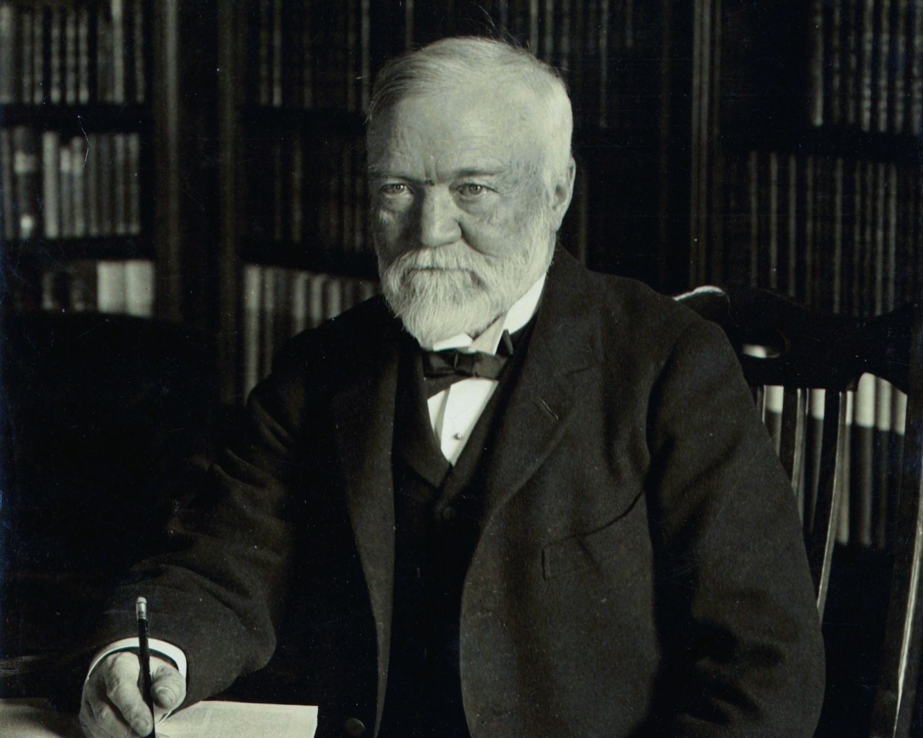 Andrew Carnegie (older gentleman) at desk, sepia tone photo